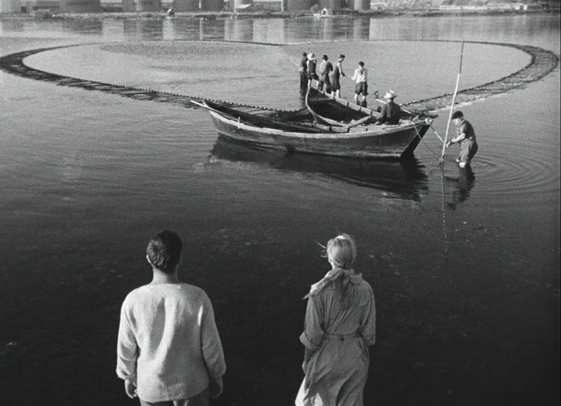 black and whit photograph of people looking at fishernet